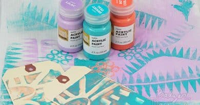 Acrylic paint pots surrounded by mixed media artwork.