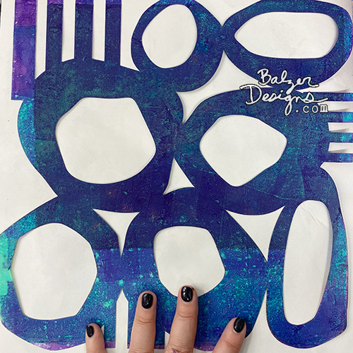 Person's fingers splayed across a Mid Century Modern Style Stencil.