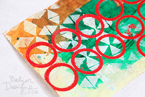 Detail of mixed media tag with red circles.