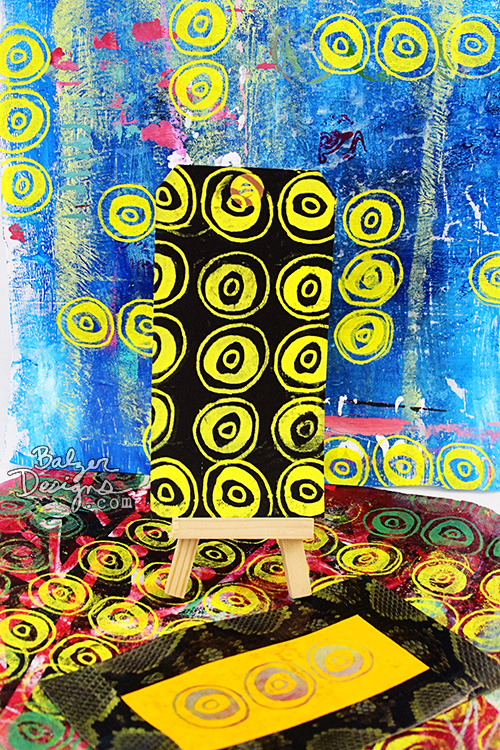 Papers and a tag all screen printed with the screen resting on the table in the photo.